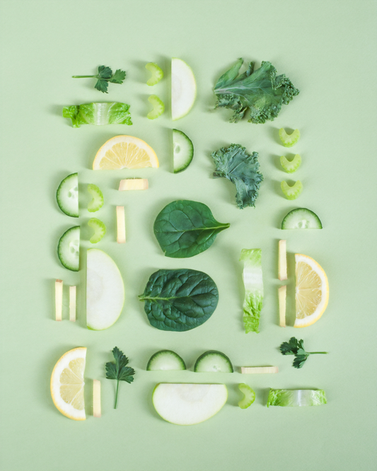 an arrangement of cucumber, salad leaves and cut lemon and kiwis.